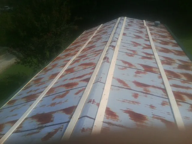 Rusted metal roof panels with new wood purlins before replacement — Storm Damage Roof Repair in Almo by Roofing Brothers