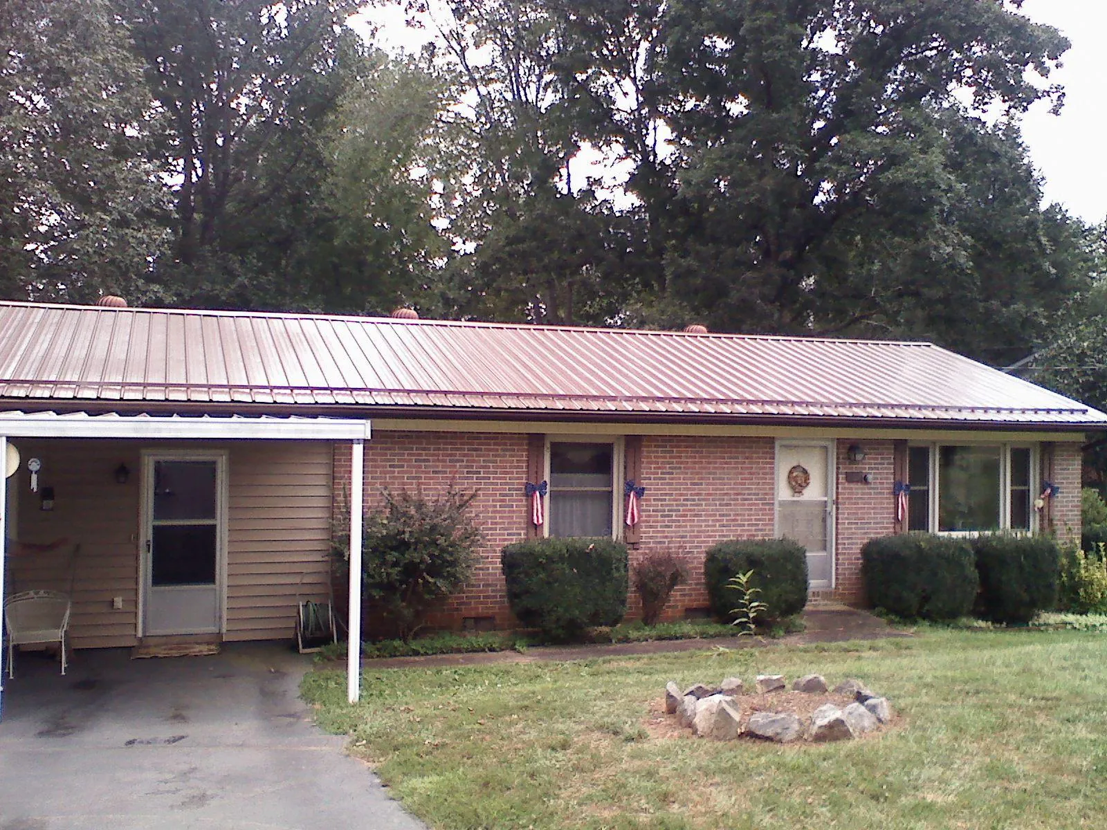 Bronze metal roof and carport on a brick ranch home — Roof Repair work by our crew in Almo