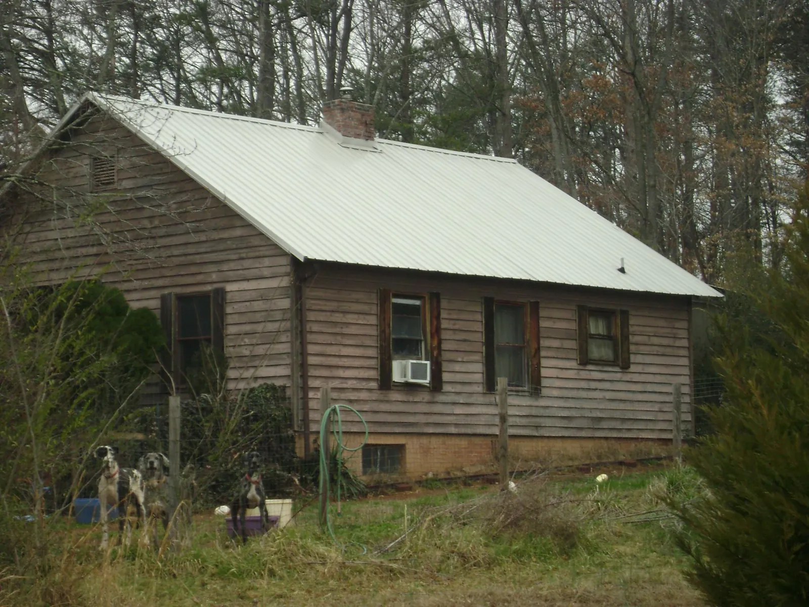 White metal roof on an old wood sided farmhouse, from a Metal Roof Installation job in Almo
